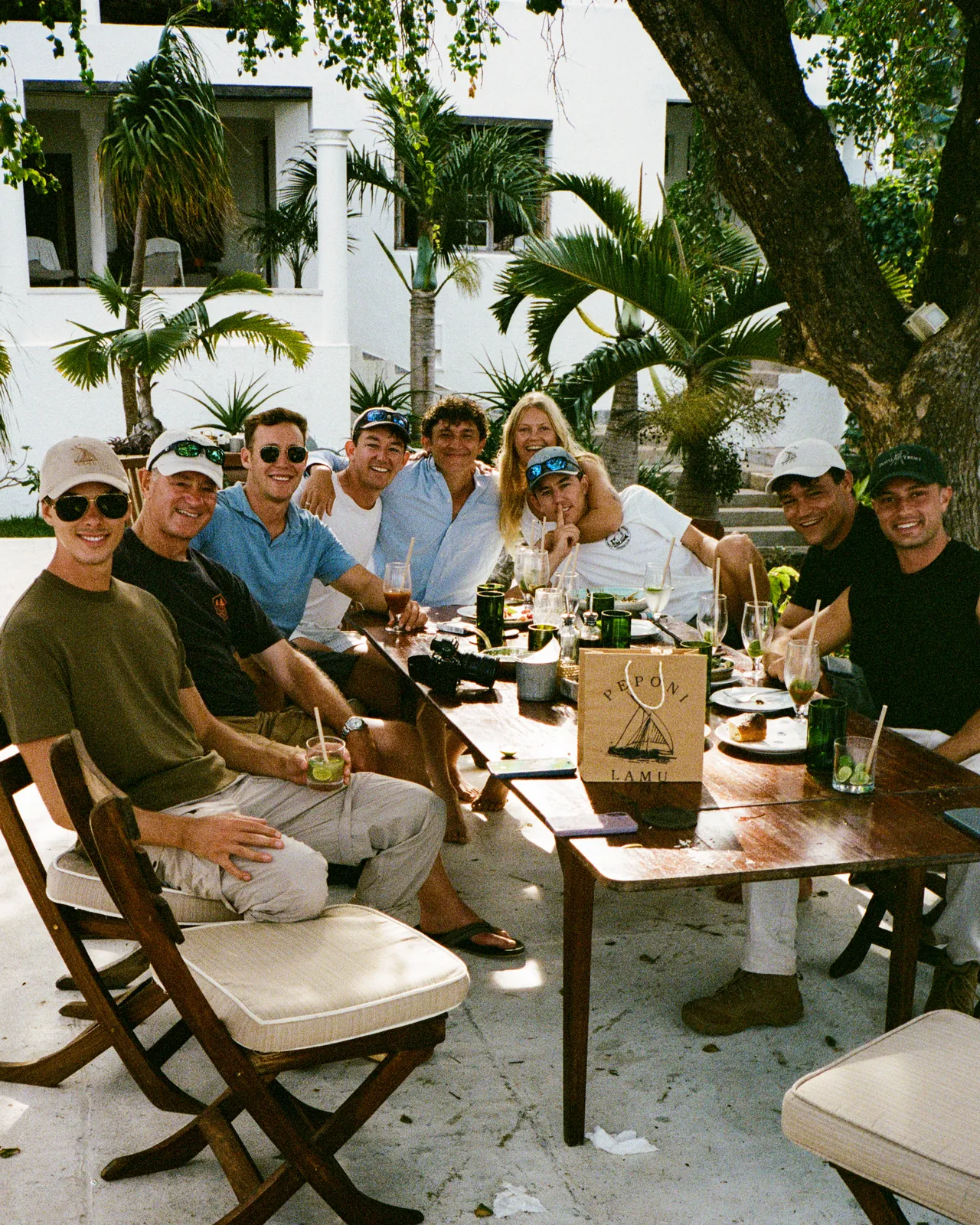 Friends and crew gathered around a long lunch table in Lamu